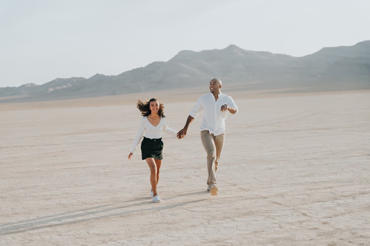 Couple running and laughing across a Las Vegas dry lake bed